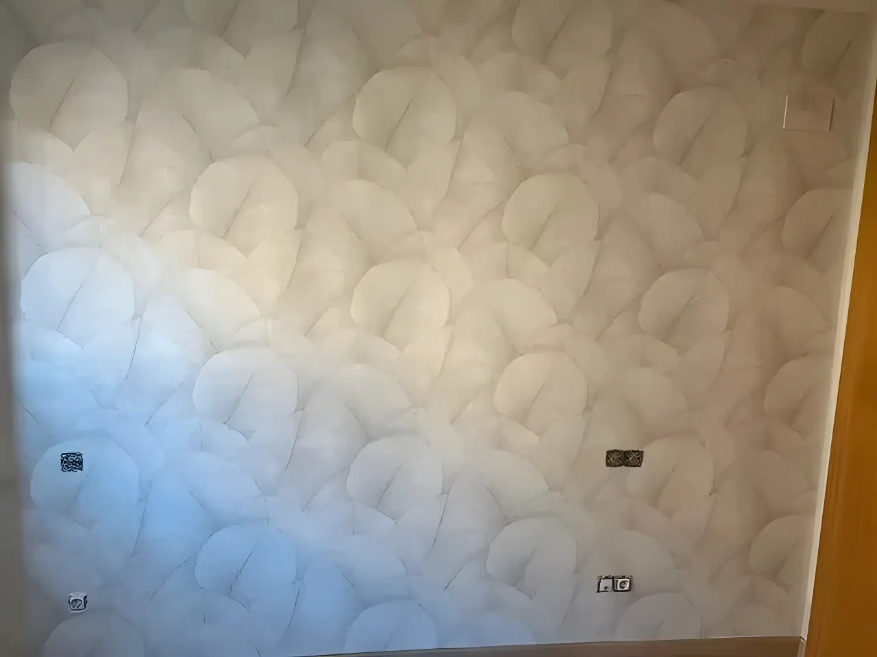 Los Pintores en Granada aplicando papel pintado de textura clara en salón reformado