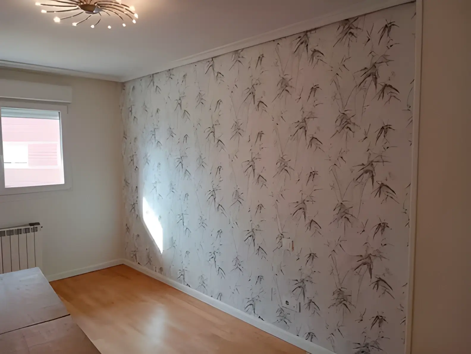 Los Pintores en Granada colocando papel pintado en pared de acento de habitación luminosa